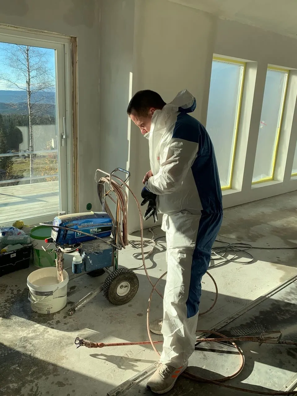Maler klargjør airless sprøyte før påføring